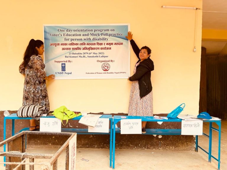 Two ladies showing the banner